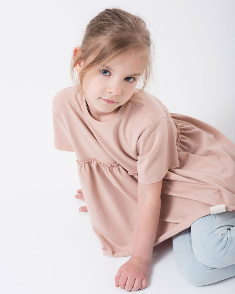 dziecko w różowej dziewczęcej bluzce z falbaną